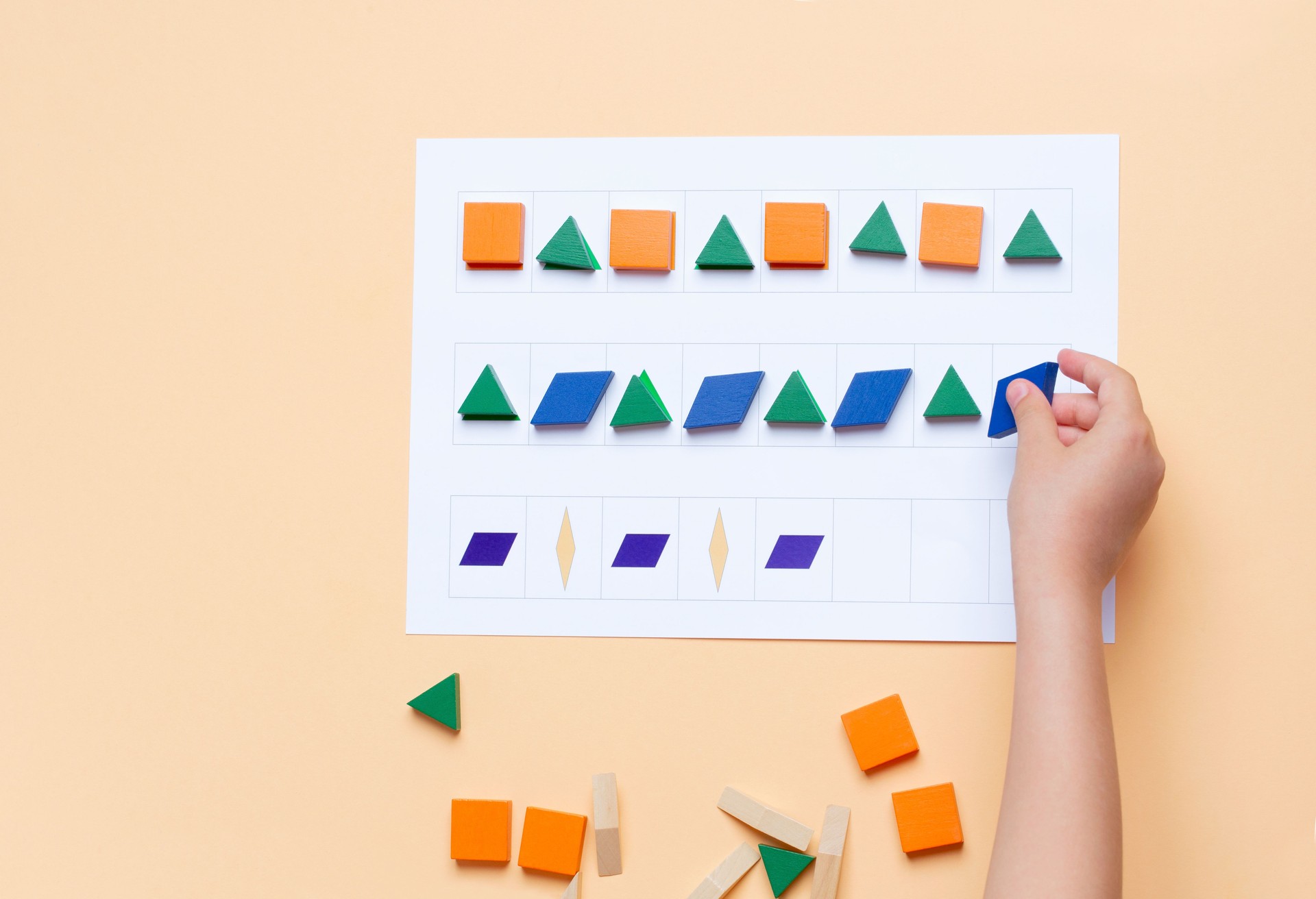 The child arranges blocks of various shapes according to the pattern. The development of thinking, attention, quick wit, imagination